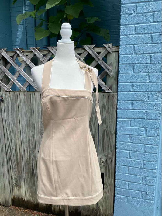 Tan sleeveless mini dress with square neckline and adjustable tie straps on mannequin.