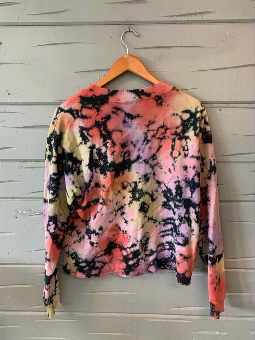 Long-sleeve crewneck shirt with vibrant multicolor tie-dye pattern in pink, black, orange, and cream tones.
