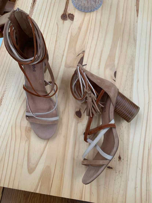 Tan suede high-heeled sandals with wooden block heels and ankle wrap straps.