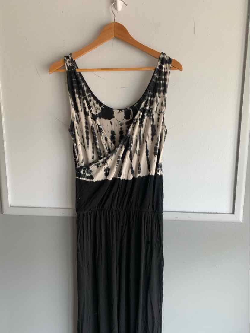 Black and beige tie-dyed sleeveless dress with scoop neckline and gathered waist hanging on wooden hanger.