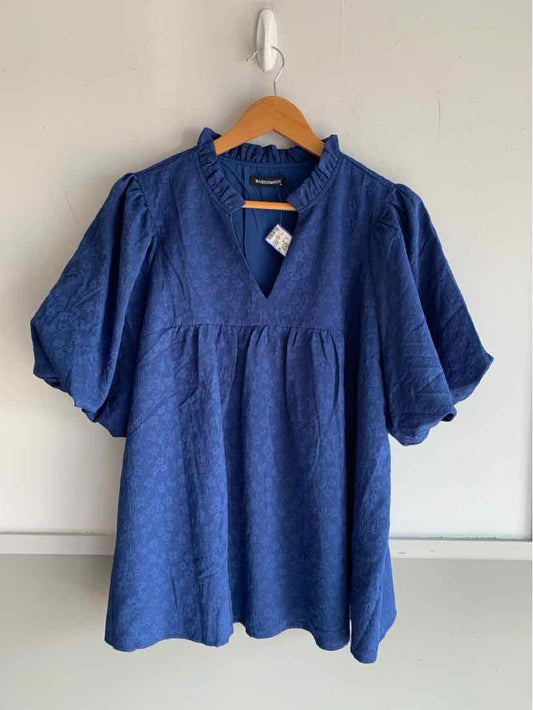 Blue short-sleeve blouse with subtle textured pattern and V-neck on wooden hanger.