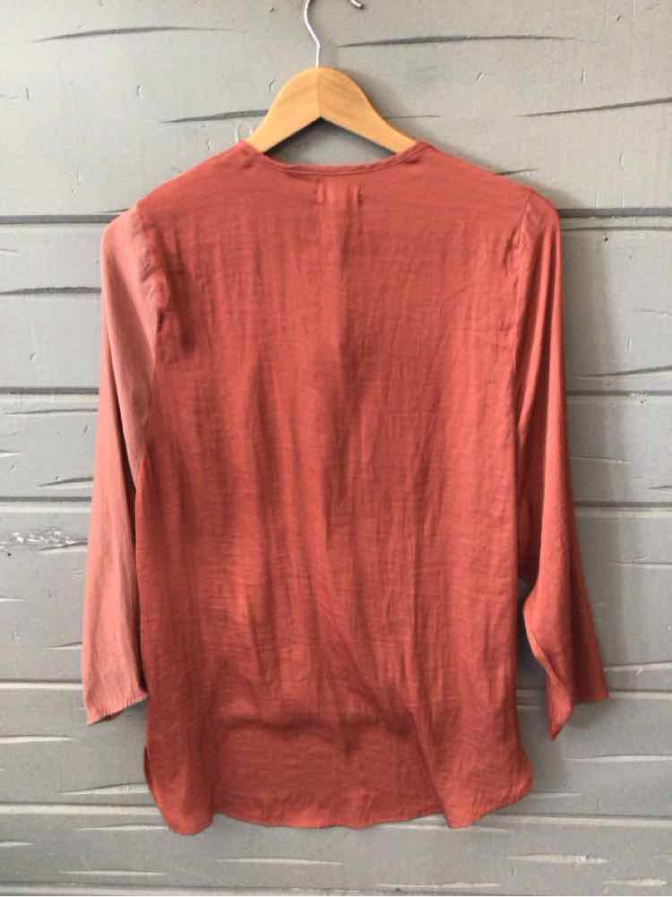 Long-sleeve women's blouse in solid burgundy with a relaxed fit and crew neckline on wooden hanger.