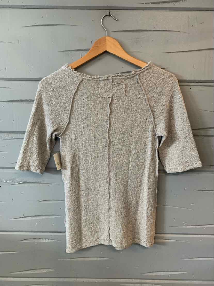Beige ribbed knit top with elbow-length sleeves and a raw edge neckline.
