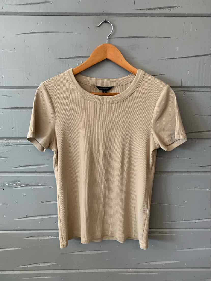 Tan short-sleeve ribbed knit top with crew neckline and fitted silhouette hanging on wooden hanger.