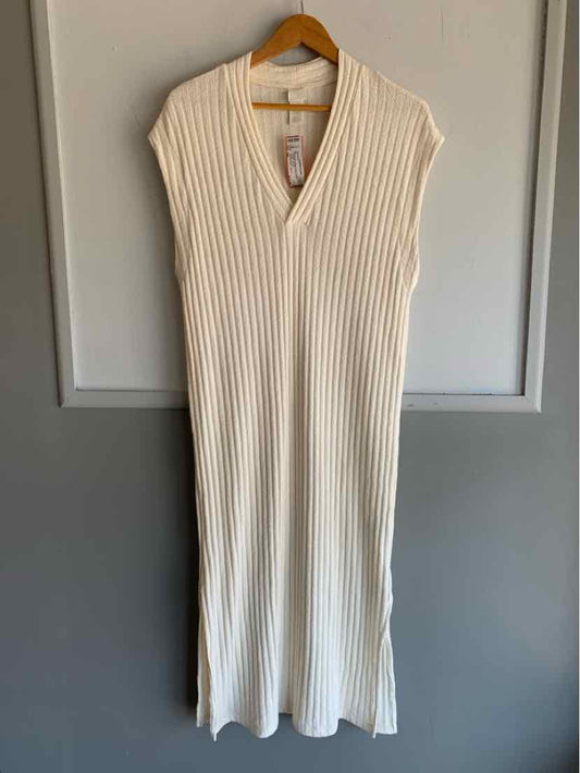 Cream ribbed knit sleeveless midi dress with V-neck hanging on wooden hanger.
