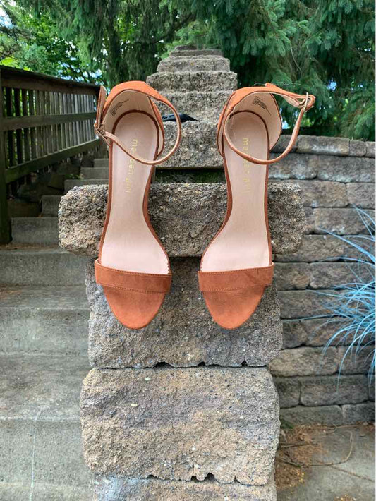 Pair of brown suede open-toe ankle strap heels with block heels and adjustable buckle closures.