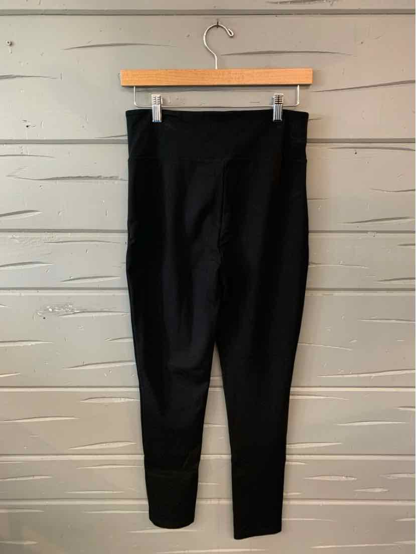 Black high-waist leggings with a smooth, stretchy fabric and a fitted ankle design hanging on a wooden hanger.