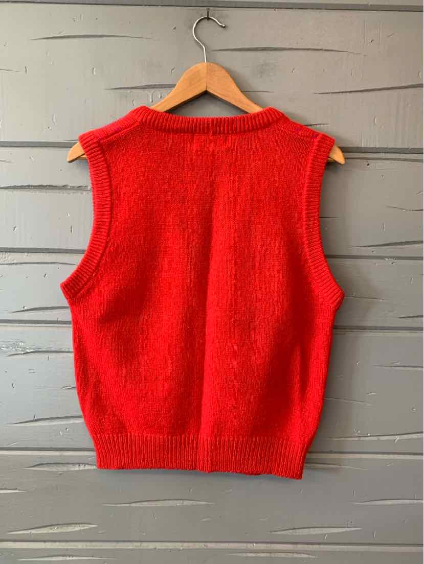 Bright red sleeveless knit vest with ribbed neckline and hem, hanging on a wooden hanger.