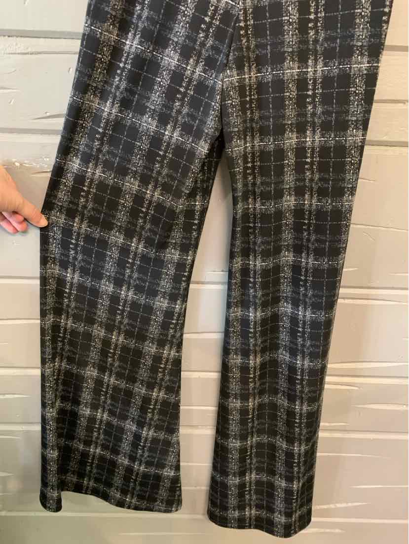 Black and white plaid straight-leg pants in small size hanging against white wall.