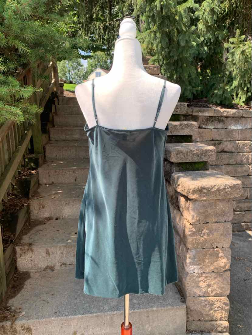 Dark green satin slip dress with thin spaghetti straps and a straight neckline.