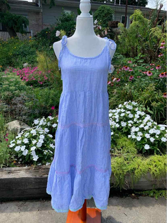 Light blue sleeveless dress with ruffled straps and tiered skirt on a mannequin outdoors.