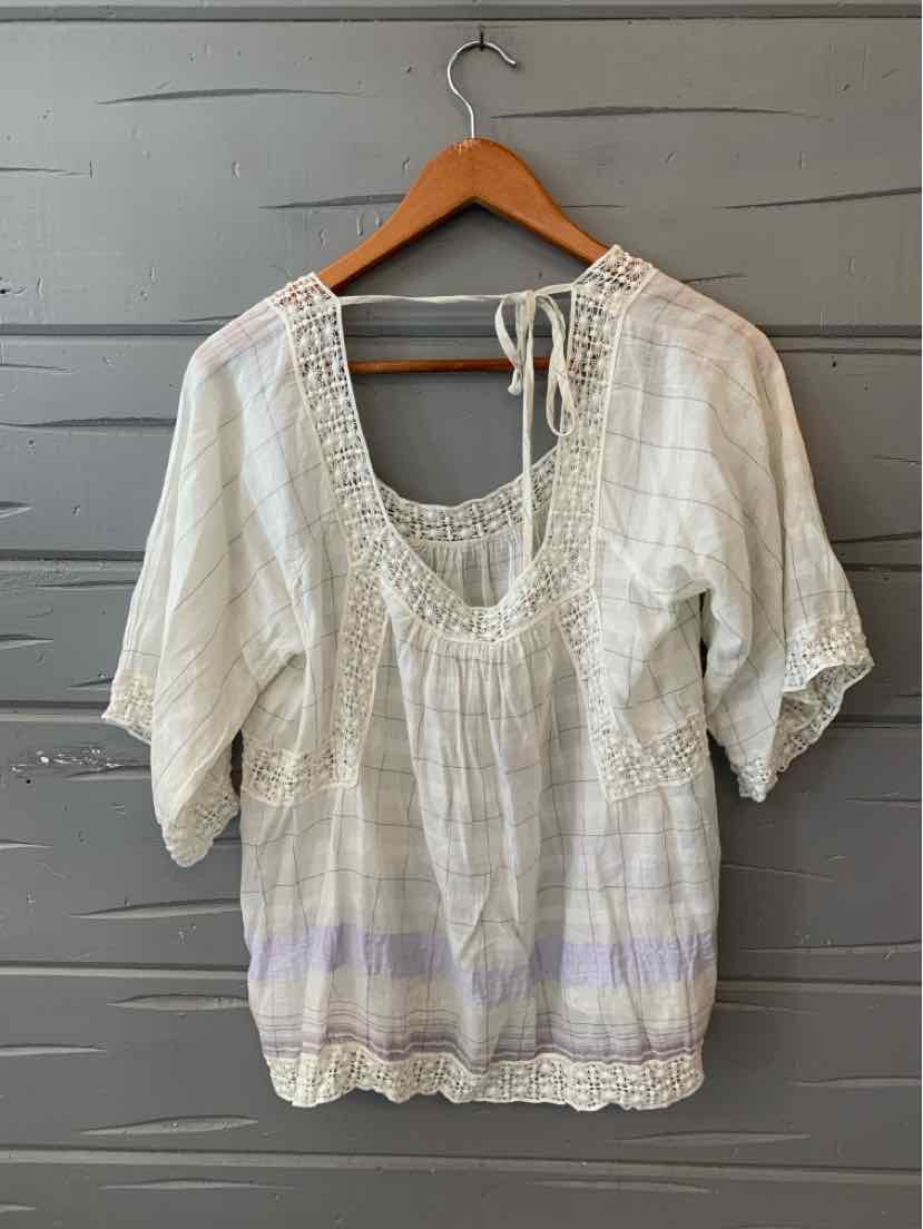 Lightweight white blouse with puff sleeves, intricate lace neckline, and subtle lavender striped hem.