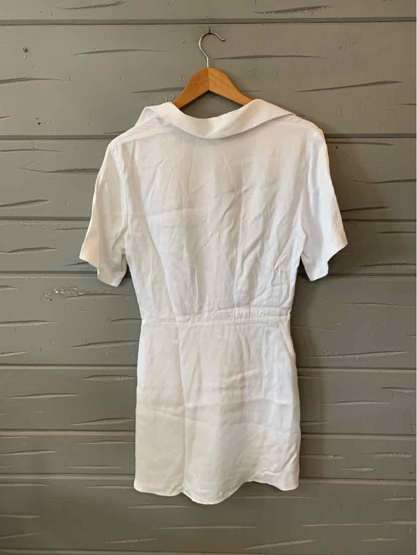 White short-sleeve mini dress with a collar and tailored waist hanging on a wooden hanger.
