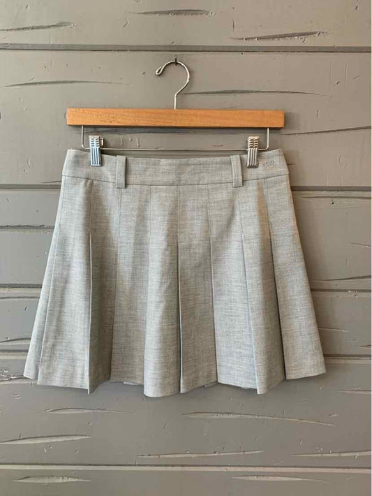 Light gray pleated mini skirt with belt loops and subtle texture on wooden hanger.