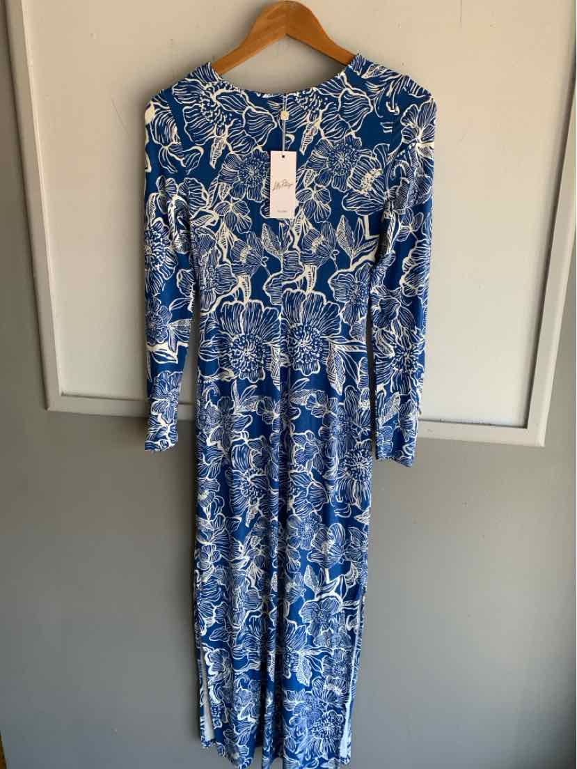 Blue long-sleeve dress with white tropical floral pattern and tag hanging on wooden hanger.