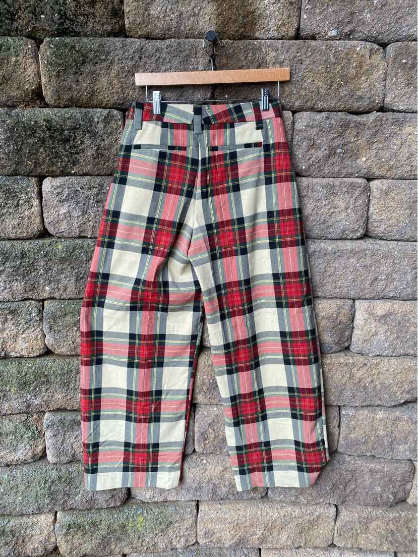 High-waisted plaid pants in red, green, black, and white with wide legs and belt loops.