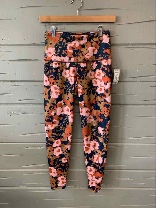 Floral print leggings with pink, orange, and black flowers on a navy background, high-waisted fit.