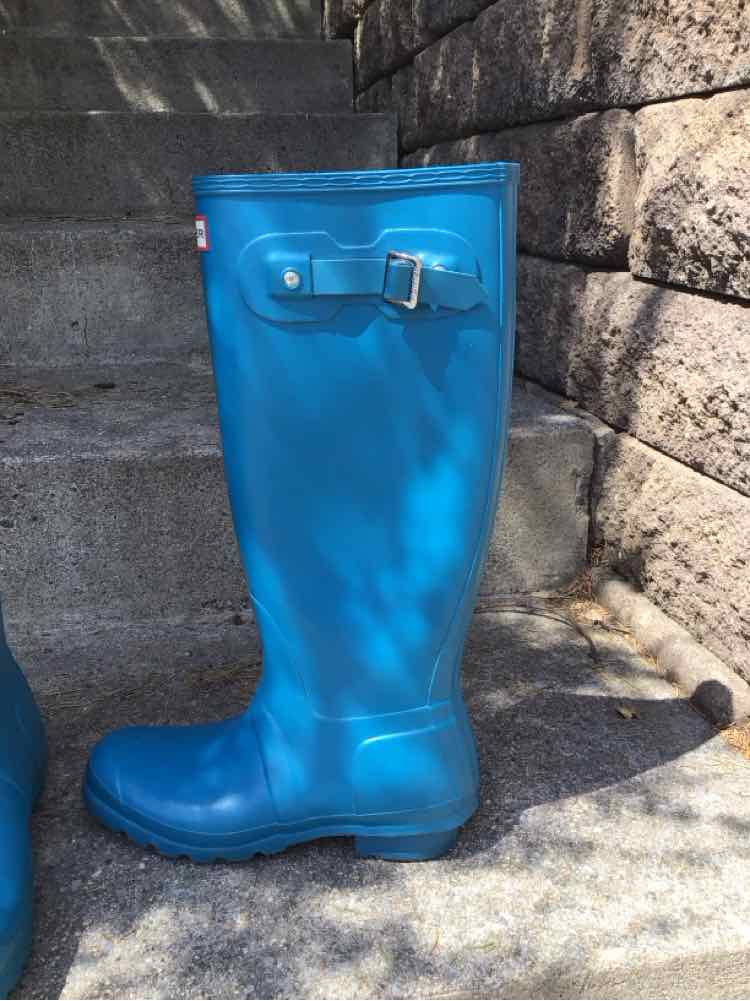 Tall blue rubber rain boot with adjustable side buckle and textured sole.