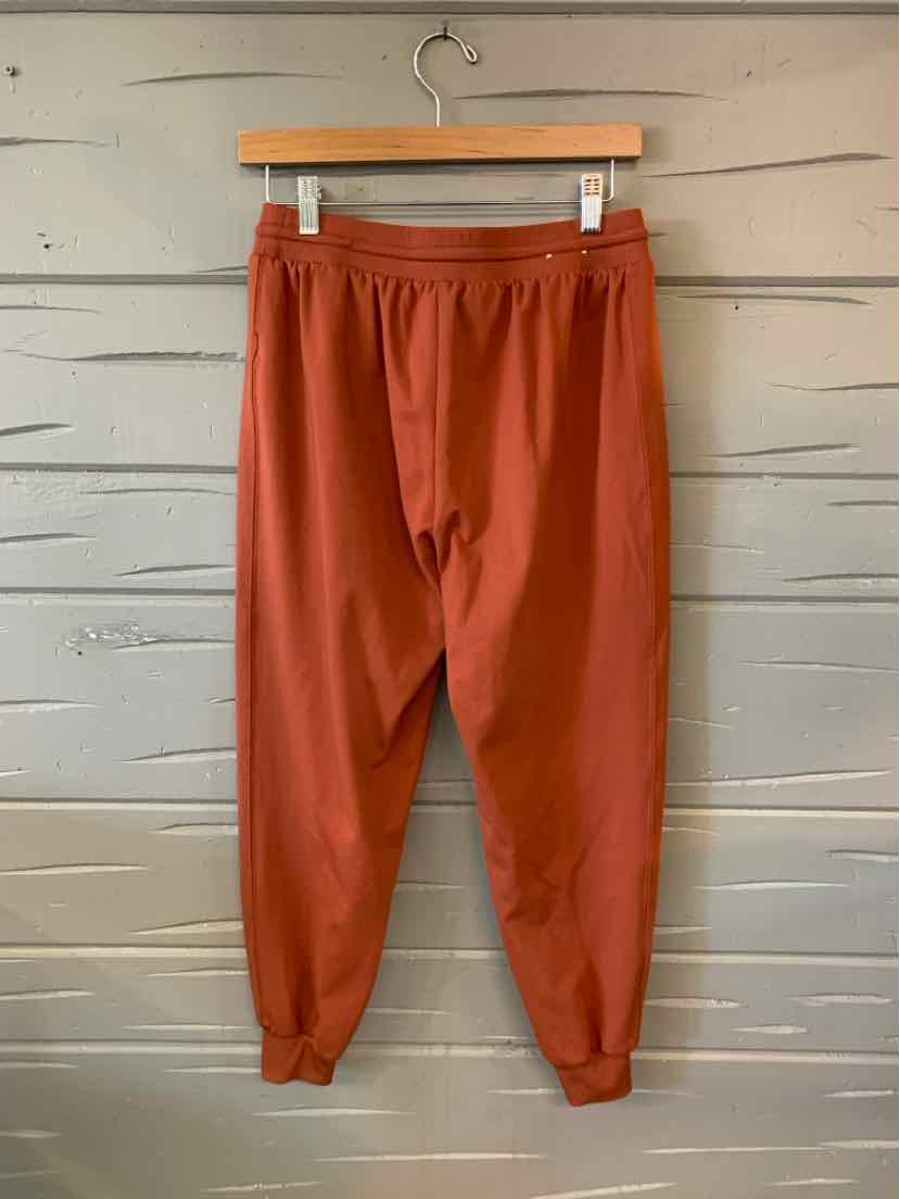 Rust-colored jogger pants in medium size with elastic waistband and cuffed ankles.