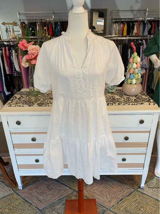 White short-sleeve dress with gathered neckline and tiered skirt on mannequin.