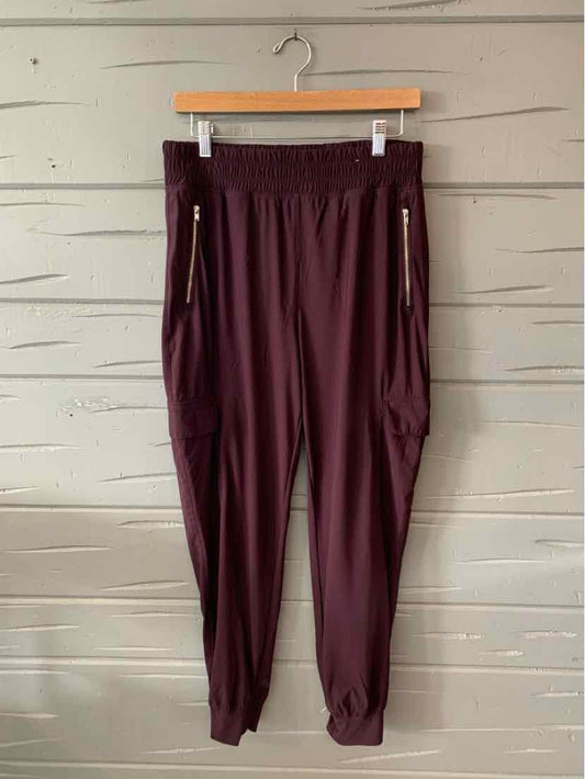 Dark plum jogger pants with elastic waistband, zipper pockets, and cuffed ankles.