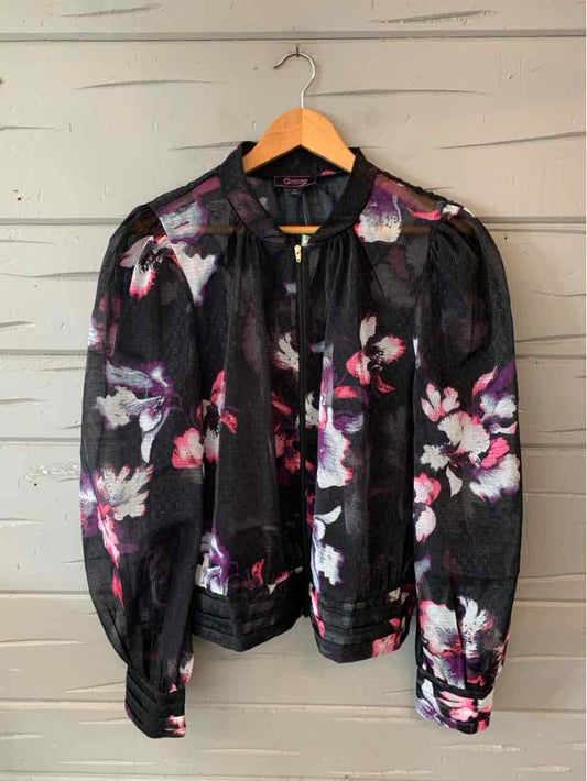 Black long-sleeve blouse with pink and white floral print, sheer fabric, and gathered cuffs.