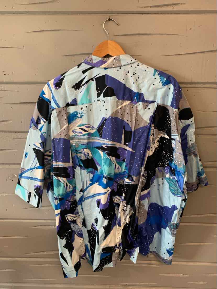 Loose-fitting button-up shirt with abstract multicolor pattern in blue, black, white, and beige, short sleeves, collar.