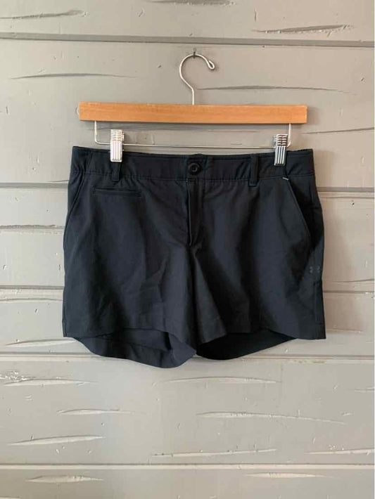 Black Under Armour women's athletic shorts with front pockets and button closure.