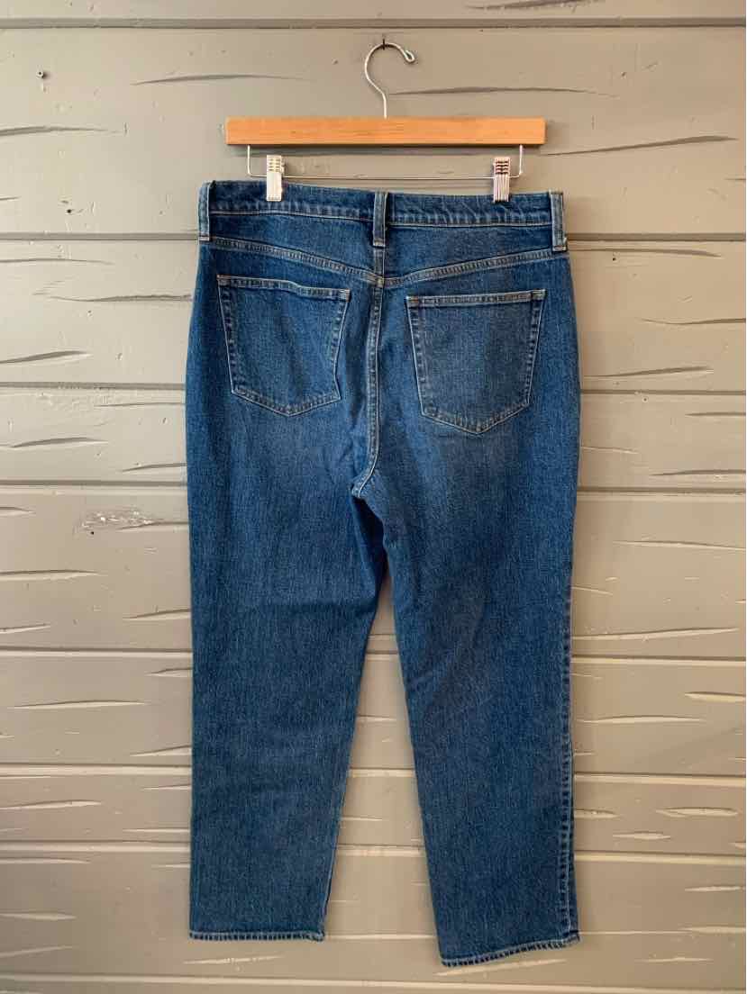 Dark blue denim J.Crew jeans size 8 with back pockets and straight leg design hanging on wooden hanger.