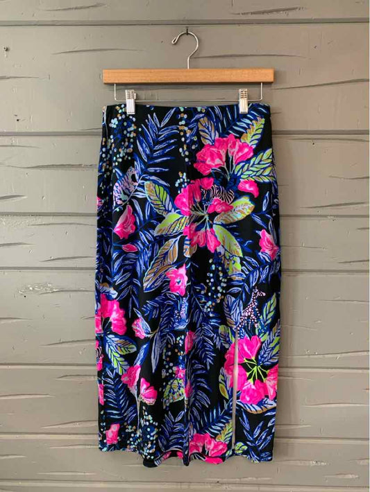 High-waisted tropical print skirt with pink, blue, and green floral pattern on black background, knee-length, lightweight.