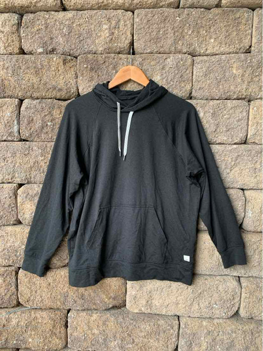 Dark gray pullover hoodie with front kangaroo pocket and white drawstring, hanging on wooden hanger.