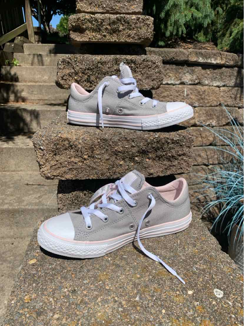 Gray low-top Converse sneakers with white rubber soles and white laces, size 6, casual style.