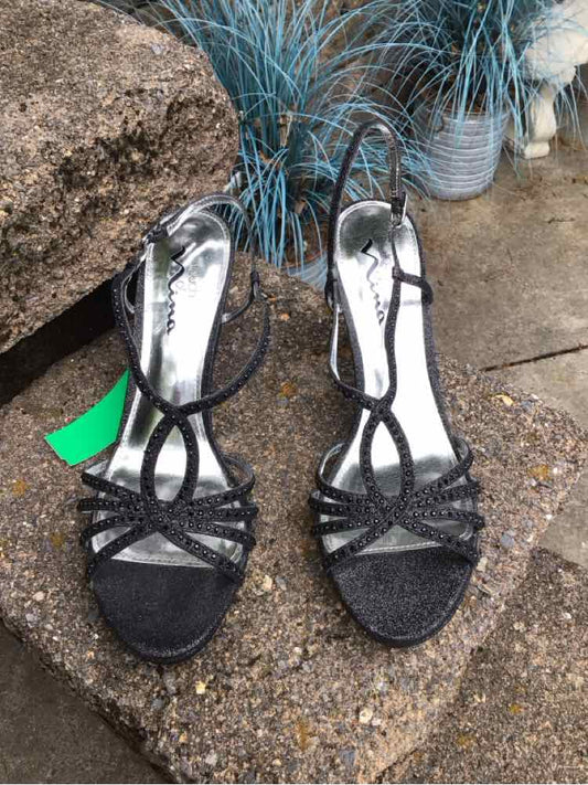 Black strappy metallic sandals with decorative loops and thin ankle straps, size 9.5.