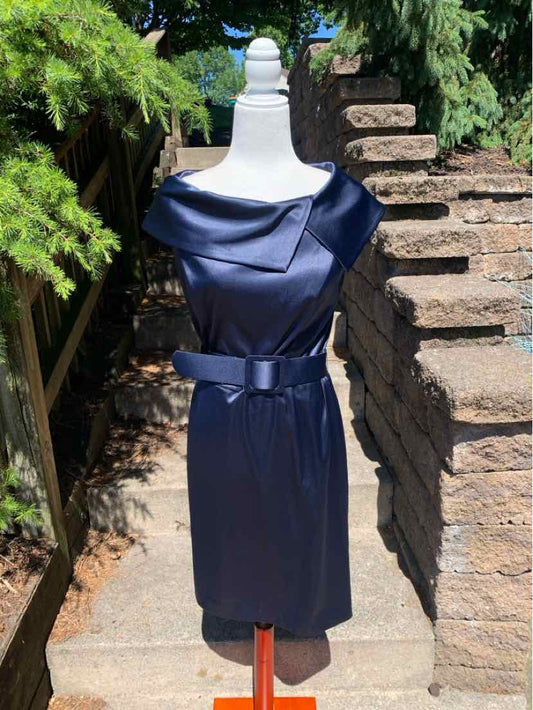 Navy blue satin sleeveless sheath dress with draped cowl neckline and matching belt at waist.