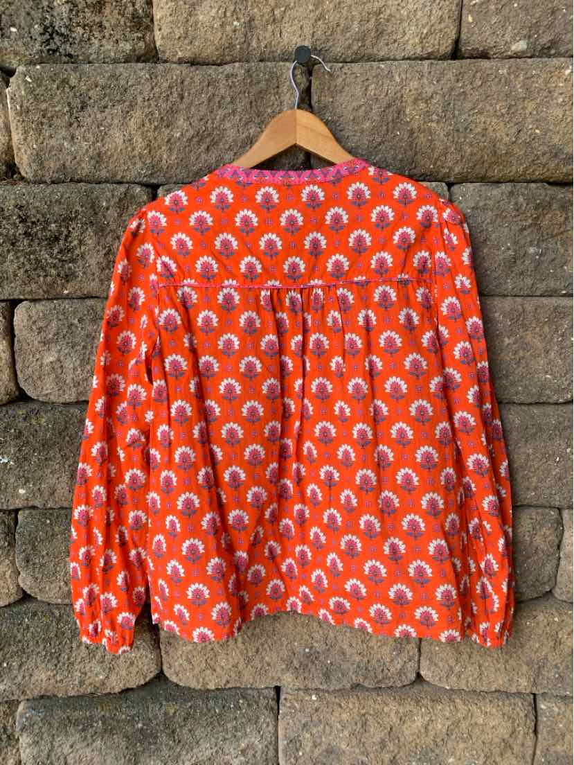 Orange long-sleeve blouse with white and pink floral circular patterns, lightweight fabric, loose fit, size large.