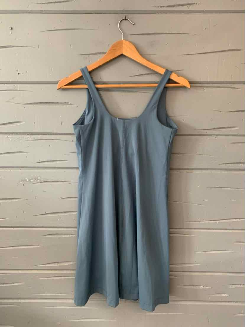 Sleeveless blue casual dress with scoop neckline and relaxed fit on wooden hanger.