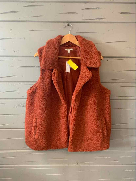 Rust-colored sleeveless fuzzy vest with shawl collar and front pockets, size 1X.