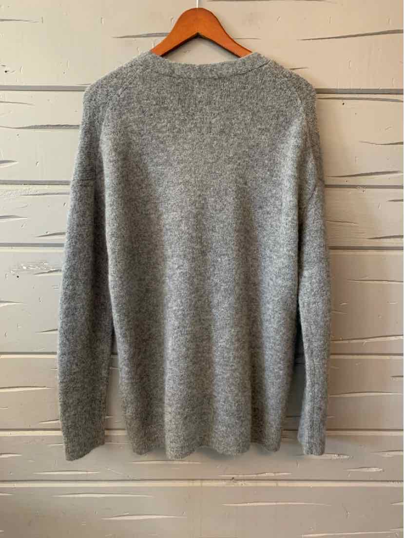 Light gray long-sleeve knit sweater with a soft texture on wooden hanger.