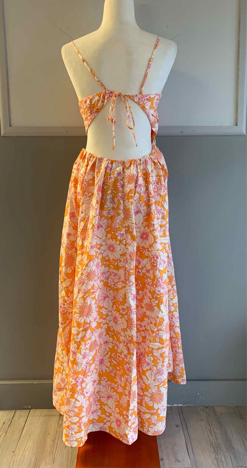 Orange and pink floral print maxi dress with open back and spaghetti straps.