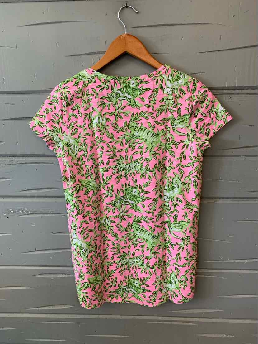 Pink and green floral patterned short-sleeve blouse on wooden hanger.