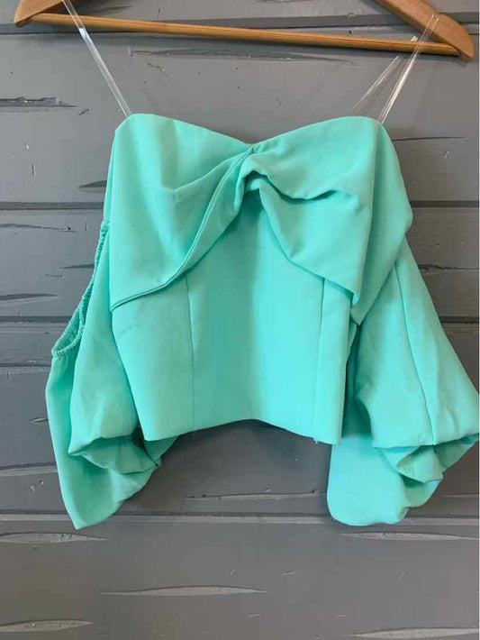 Mint green off-shoulder crop top with puffy long sleeves and front bow detail on wooden hanger.
