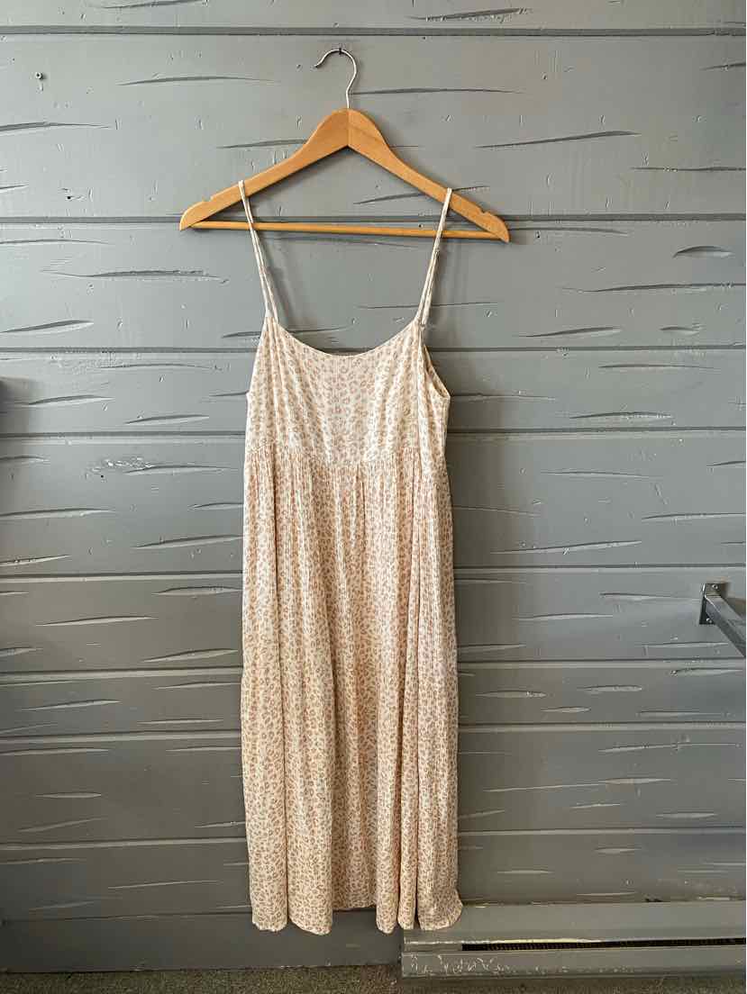 Cream cheetah print sleeveless midi dress with spaghetti straps on wooden hanger.