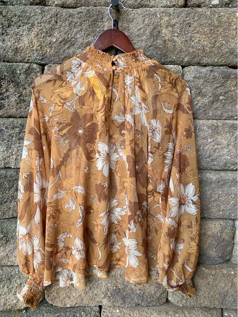 Light brown floral blouse with high collar and gathered cuffs, lightweight fabric.