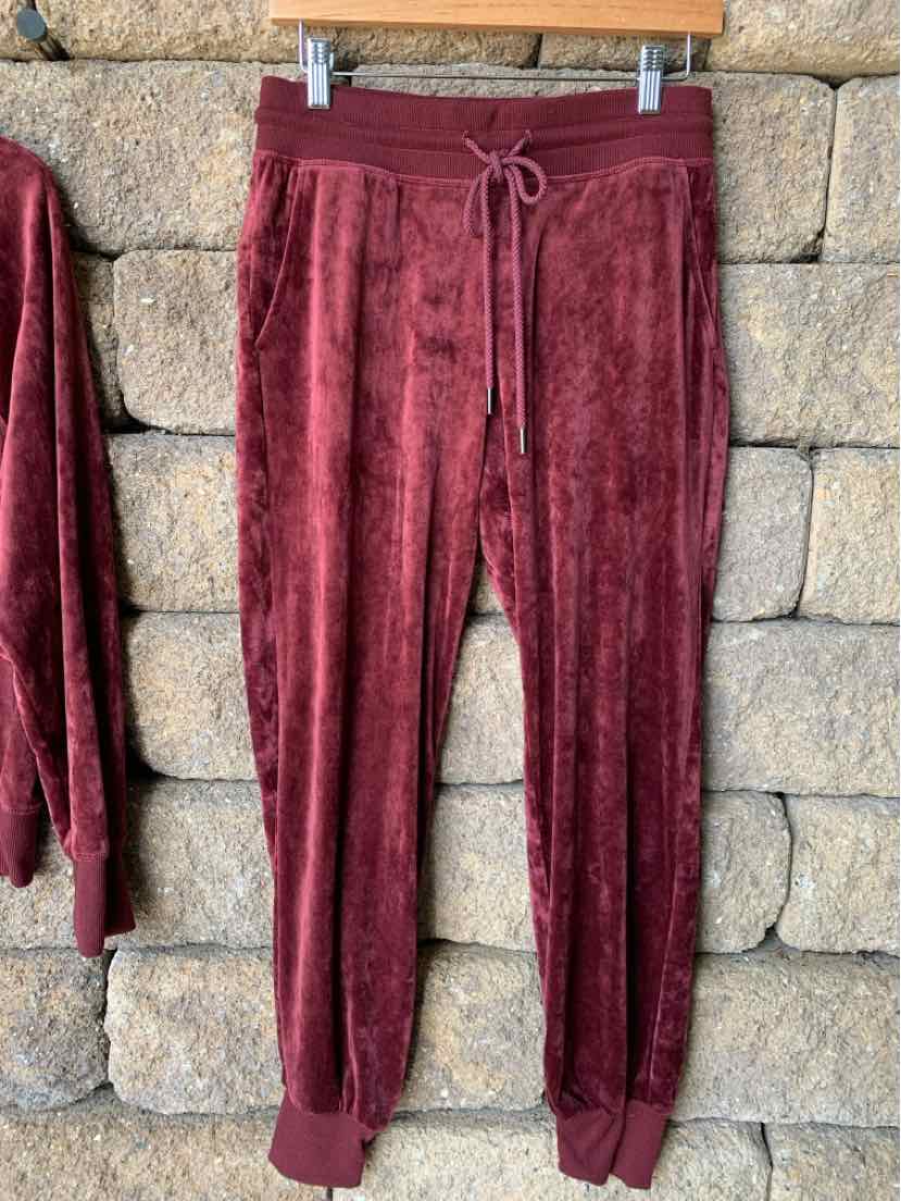 Burgundy soft velvet jogger pants with drawstring waist and ribbed cuffs.