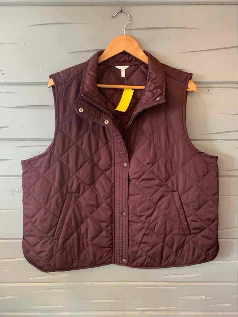 Quilted burgundy sleeveless vest with snap buttons and two front pockets on wooden hanger.