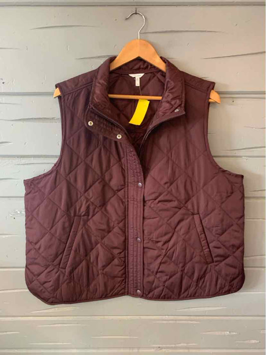 Quilted burgundy sleeveless vest with snap buttons and two front pockets on wooden hanger.