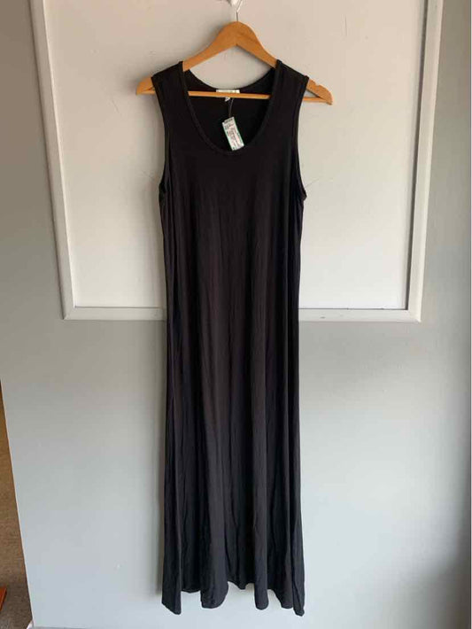 Black sleeveless maxi dress with scoop neckline hanging on wooden hanger.