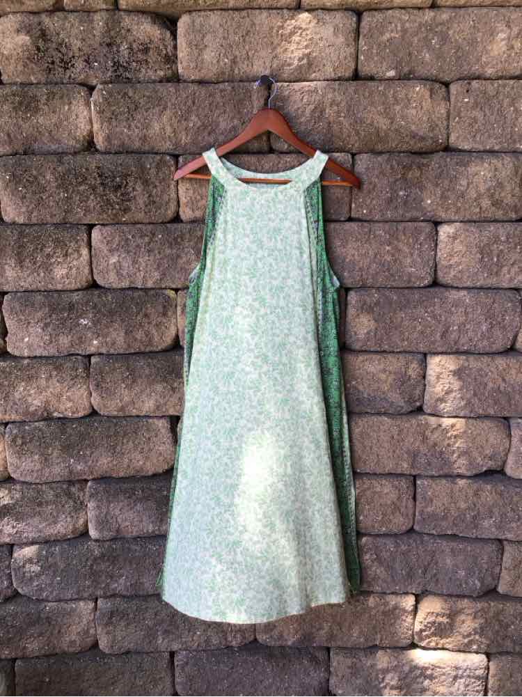 Light green sleeveless midi dress with a subtle floral pattern and a round neckline.