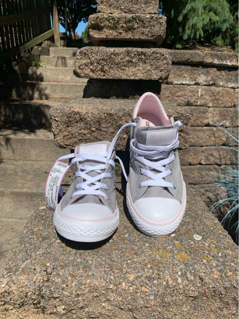 White high-top Converse sneakers with pink inner lining, white laces, and rubber soles.