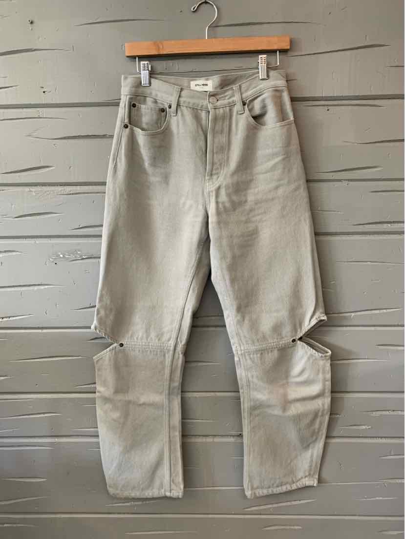 Light gray denim jeans with high waist and relaxed fit, featuring front pockets and knee cutouts.